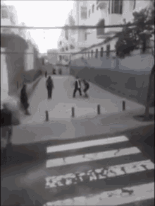 a black and white photo of people walking on a street with a sign that says " a " on it