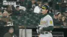 a baseball player wearing a green and white uniform with the number 8 on the back