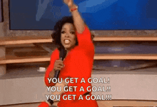 oprah winfrey is holding a microphone and saying you get a goal !