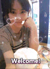 a woman sits at a table with a cup of coffee and a welcome message