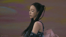 a woman with pigtails in her hair is standing in front of a colorful wall .