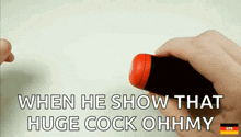 a person is holding a red object with the words `` when he show that huge cock ohhmy '' written on it .
