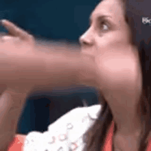a close up of a woman 's face with a hand coming out of her mouth .