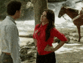 a woman in a red shirt stands next to a man in a white shirt