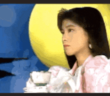 a woman in a pink dress is looking at the moon .