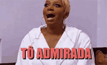 a woman in a white robe is sitting with her mouth open and the words `` to admirada '' written in red .