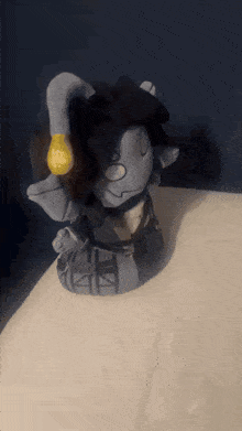 a stuffed animal with a yellow light bulb in its hand