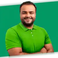 a man in a green shirt with his arms crossed smiles