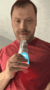 a man in a red shirt holding a light bulb