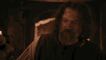 a man with a beard sits next to another man in a bathtub