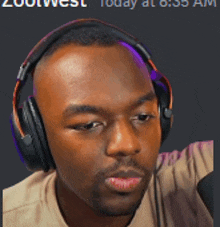 a man wearing headphones is sitting in front of a screen that says zootwest today at 6:35 am