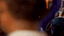 a close up of a person 's eye with a purple object in the foreground .