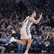 a basketball player wearing the number 23 jersey is running on the court