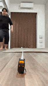 a man is standing next to a measuring tape on the floor