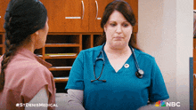 a nurse with a stethoscope around her neck is talking to another nurse in a nbc ad