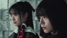 two girls are standing next to each other and looking at each other .