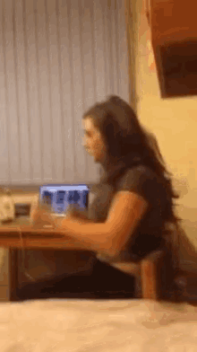 a woman sitting at a desk with a laptop on it