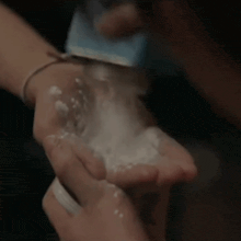 a person is pouring powder into their hand