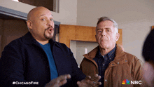 two men standing next to each other with a nbc logo on the bottom