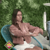 a woman is sitting in a chair with her eyes closed and her hands outstretched .