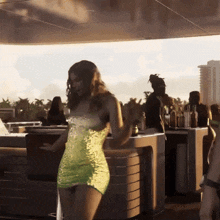 a woman in a yellow dress is dancing in a bar