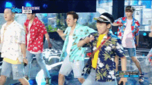 a group of men are dancing on a stage with a btob logo in the corner