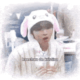 a person wearing a bunny hat with a rabbit on it is sitting at a table .