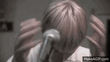 a close up of a person holding a microphone in their hand .