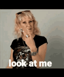 a woman is making a funny face and says " look at me "
