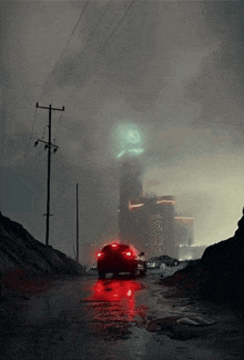 a red car is driving down a wet road in front of a city