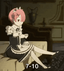 a girl in a maid outfit is sitting on a couch holding a cup of tea .