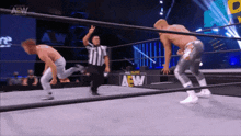 two wrestlers are in a ring with a aew logo on the wall