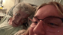 a woman wearing glasses sits next to an older woman with glasses