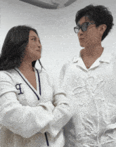 two women standing next to each other with one wearing a shirt with the letter b on it