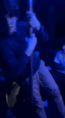 a group of people sitting around a table in a dark room with blue lights