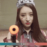 a woman with a crown on her head holds a gun