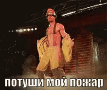 a man in a fireman 's uniform is dancing on a stage with a caption in russian