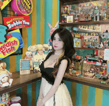 a woman stands in front of a display of toys and a bubble yum box