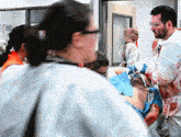 a man in a bloody lab coat is carrying another man