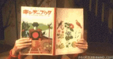 a person is reading a book with foreign writing on the cover