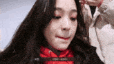 a woman in a red hoodie is making a funny face in a video