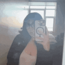 a woman is taking a picture of herself in a mirror with her phone .