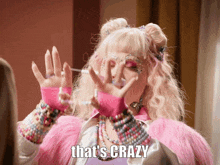 a woman in a pink fur coat has the words that 's crazy on her face