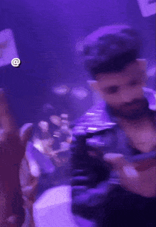 a man with a beard wearing a black leather jacket is making a heart shape with his hands .