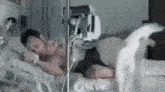 a man is laying in a hospital bed with an oxygen mask on his chest .