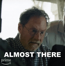 a man wearing glasses and a plaid shirt says " almost there " on the bottom