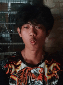 a young man wearing a shirt with a tiger on it making a face
