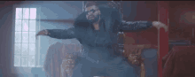 a man in a black leather jacket and sunglasses is dancing in a room .