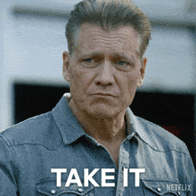 a man wearing a denim shirt with the word takeit on it