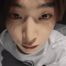 a close up of a person 's face with a white shirt that says ' abercrombie & fitch ' on it